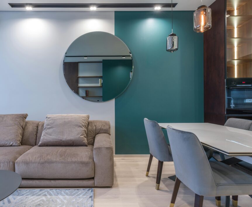 round mirror hanging above a sofa in a contemporary apartment