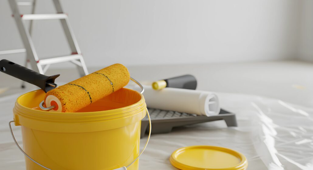 a yellow paint bucked and roller